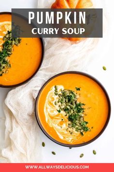 two bowls filled with pumpkin curry soup on top of a white table