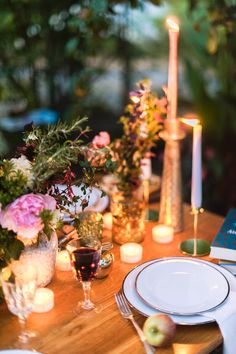 the table is set with candles and plates