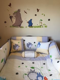 a child's bed with winnie the pooh wall decals and pillow cases