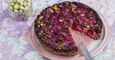 a cake on a plate with a knife and some nuts next to it, ready to be eaten