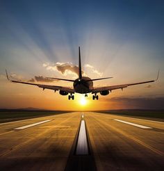 an airplane taking off from the runway at sunset