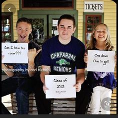 three people sitting on a bench holding signs in front of their faces with words written on them