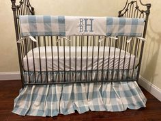 a baby crib with a blue and white checkered bed skirt on the bottom