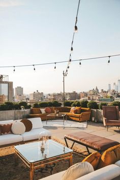 an outdoor seating area with couches, tables and chairs on top of a roof