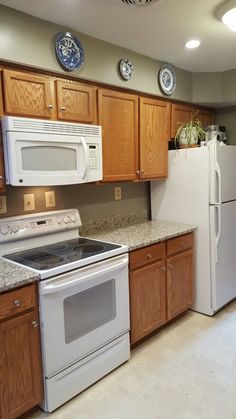 a kitchen with wooden cabinets and white appliances