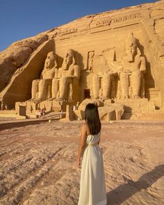 a woman standing in front of an egyptian temple