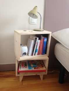 a book shelf with books on it next to a lamp and bed in the background