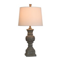 a table lamp with a white shade on it's side and a wooden base