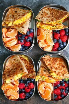 four trays filled with different types of food and fruit on top of each other