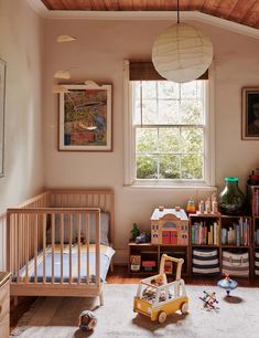 a child's room with toys and bookshelves on the floor in front of a window