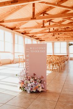 a welcome sign sitting on top of a tile floor next to wooden chairs and tables