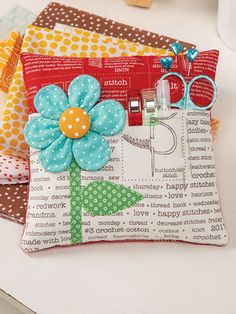 three small purses with flowers on them sitting on top of a white table next to each other