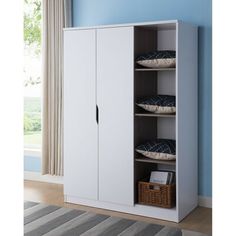 a white cabinet with pillows on it and a basket next to it in front of a blue wall