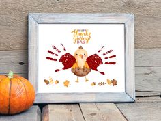 a turkey is sitting next to an orange pumpkin on a wooden table with the words happy thanksgiving