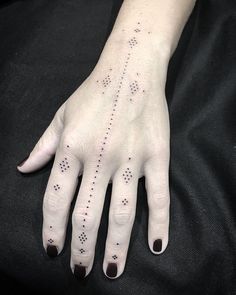 a woman's hand with dots and lines on her left wrist, which are drawn in black ink