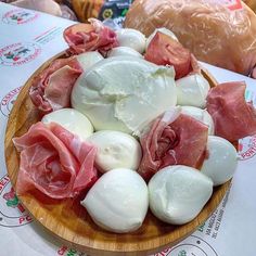 a wooden plate topped with lots of meat and veggies on top of a table