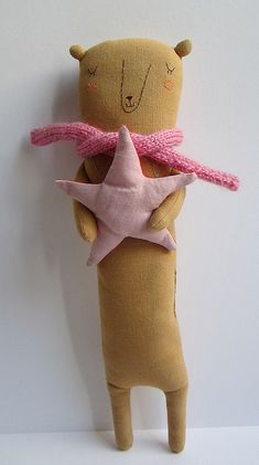 a teddy bear holding a pink star on its back