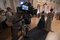 a cameraman filming two women in formal dress