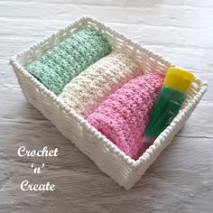 three crochet washcloths in a white basket