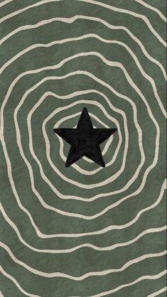 a black star sitting in the middle of a green and white swirly area with wavy lines