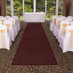 the room is set up with white chairs and gold sashes