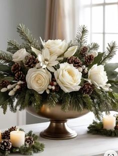 a vase filled with white flowers and pine cones