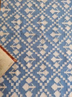 an open book sitting on top of a blue and white rug