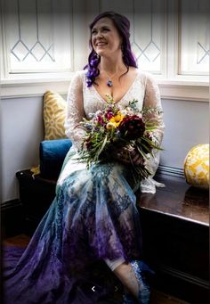 a woman sitting on a bench holding a bouquet