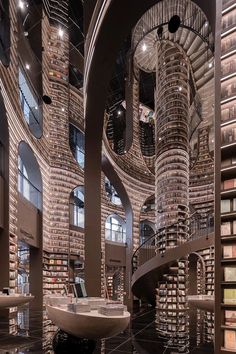 the interior of a large library with many bookshelves and spirally staircases