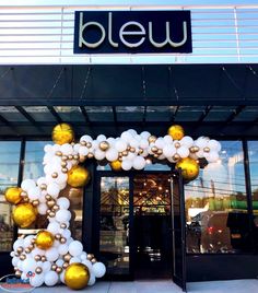 the entrance to bleu is decorated with gold and white balloons