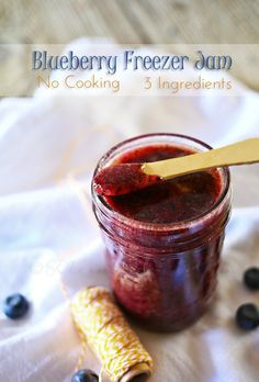 blueberry freezer jam in a jar with a wooden spoon and corn on the side