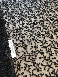 a lot of black beads sitting on top of a wooden floor next to a sign