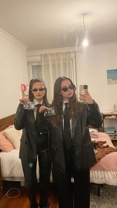 two people in suits and sunglasses taking a selfie