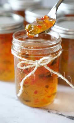 the absolute best hot pepper jelly recipe in a glass jar with a spoon full of it