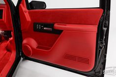 the interior of a red car with its door open