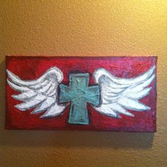 a cross with white wings painted on it