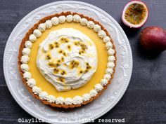 there is a pie with white frosting and fruit on the plate next to it