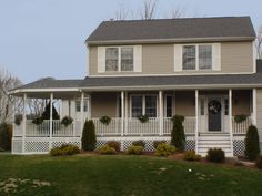 a house with white trim and porches in the front yard