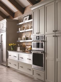 a kitchen with white cabinets and stainless steel appliances, including an appliance that is built into the wall