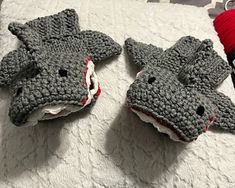 two crocheted animal mittens sitting on top of a bed