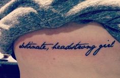 a woman's lower back tattoo with the words ultimate, healthy girl written in cursive font