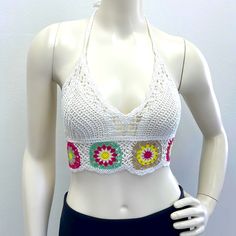 a mannequin wearing a white top with colorful crochet