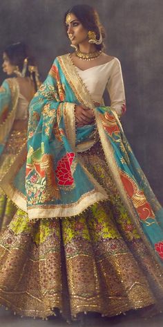 a woman in a blue and green lehenga