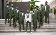 a group of men in green suits standing on steps