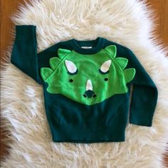 a green sweater with an image of a koala on it