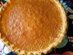 a pie sitting on top of a colorful table cloth