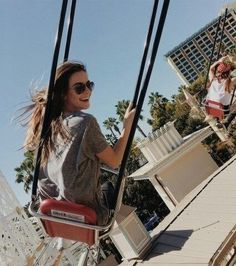 a woman riding on the back of a red swing