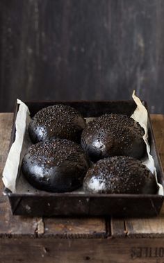 chocolate donuts sitting in a box on top of a wooden table