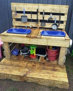 an outdoor kitchen made out of pallets and wooden pallets with blue pots on top