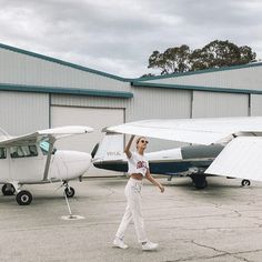 a woman standing in front of two small planes